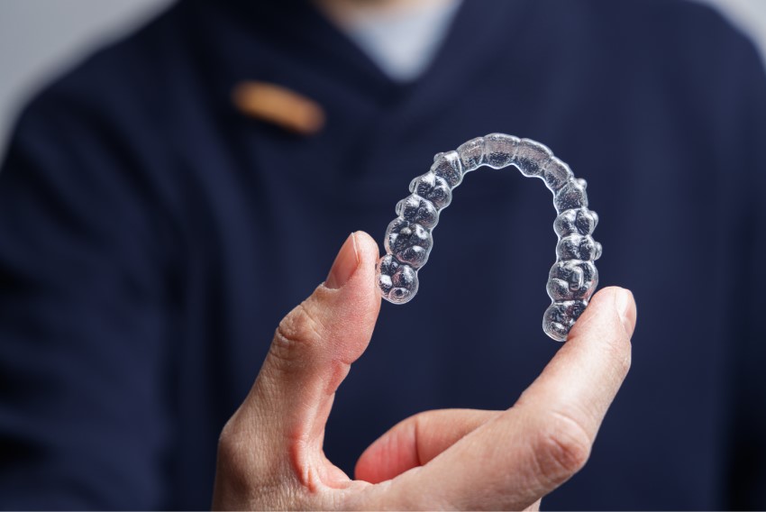 Dentist holding clear aligners